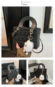 Détail du sac matelassé noir avec pendentif peluche et bandoulière en cuir amovible