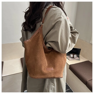 Brown suede underarm tote bag showing draping effect and textured material on shoulder
