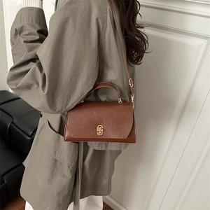 Sac à main vintage en cuir marron avec boucle dorée et bandoulière élégante