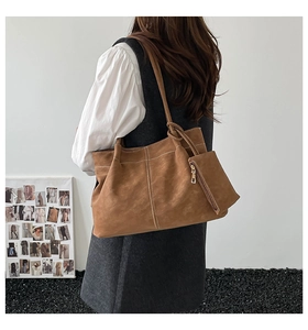 Detailed view of brown suede tote bag with contrast stitching and small side pouch