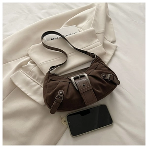 Détail d'un sac bandoulière rétro en daim marron avec boucle en métal et plis
