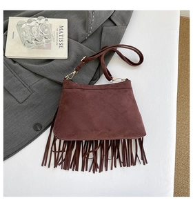 Detail der braunen Schultertasche aus Wildlederimitat mit langen Fransen und Goldbeschlägen