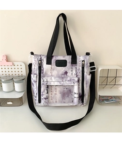 Detail of white canvas tote bag with purple calligraphy and adjustable nylon shoulder strap