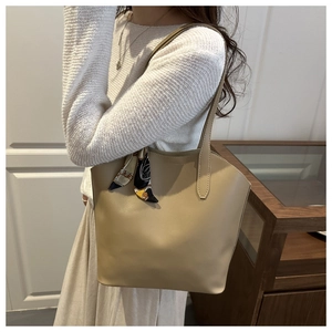 Detail der beigen Leder-Tote-Bag mit stilvollem geometrischem Halstuch am Griff