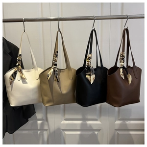 Detailed row of tote bags in beige, khaki, black and brown with decorative silk scarves