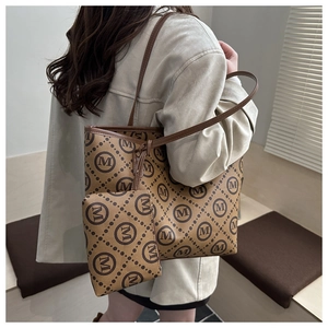 Detail view of stylish tote bag set with monogram print and matching small pouch
