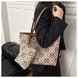 Close-up of a stylish monogram tote bag set with a matching small coin purse for women