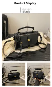 Dettaglio della borsa squadrata in pelle nera con chiusura dorata e manico fisso