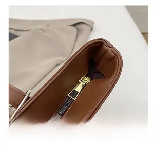 Macro shot of smooth metal zipper and premium leather texture on a brown tote bag