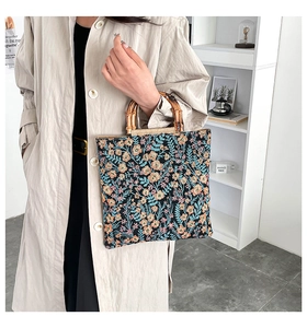 Detail of floral tote bag showing vintage fabric texture and natural bamboo handle