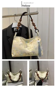 Detail of yellow brocade bucket bag with wooden bead handle and silk tassel