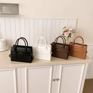Collection of faux crocodile texture handbags in four colors on a minimalist background