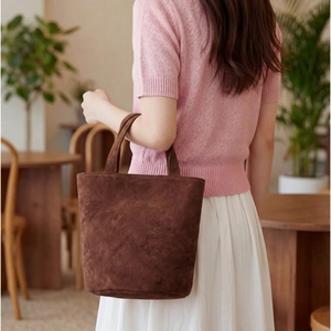 Grande borsa tote in pelle scamosciata marrone scuro in stile retrò in un caffè