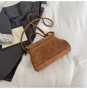 Detail shot of brown frosted texture tote bag with wooden bead charm and suede finish