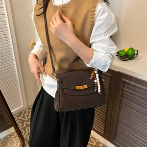 Deep brown matte leather crossbody bag with gold twist lock and colorful bead pendant
