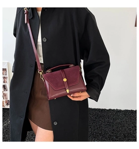 Détail du sac bandoulière en cuir PU bordeaux avec fermoir métallique sur un modèle
