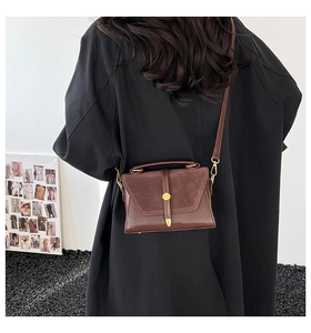 Vue détaillée du sac bandoulière en cuir marron avec boucle dorée et bandoulière réglable