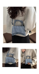 Close-up of vintage blue denim handbag with knot handle and adjustable strap on model