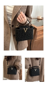 Detail of leopard print crossbody bag featuring a golden V-shaped buckle and plush texture