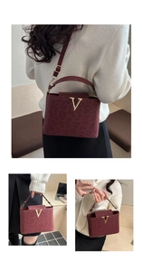Detailed view of burgundy leopard-embossed tote with a prominent gold V-shaped buckle