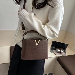 Stylish leopard print tote bag with gold V hardware and a sleek crossbody strap