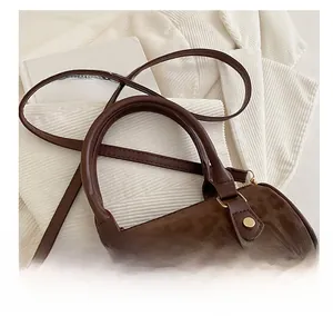 Detail of brown leopard print boston bag with gold hardware and embossed texture