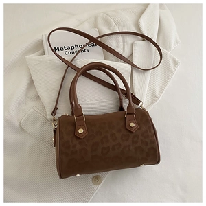 Detailed view of brown leopard print Boston bag with gold hardware and shoulder strap
