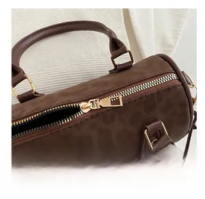 Detailed macro view of the smooth golden metal zipper on this leopard print boston bag