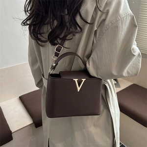 Minimalist V-accented dark brown pebbled leather bucket bag with top handle and strap
