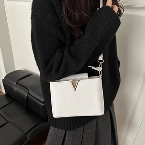 Minimalist white leather crossbody bag with golden V-shaped metal hardware for women