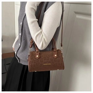 Detail of leopard print Boston bag with gold hardware and adjustable shoulder strap
