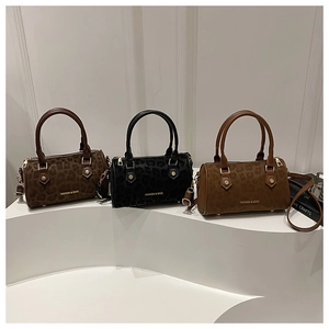 Three leopard print cylinder Boston bags in brown, black and tan on white display stand