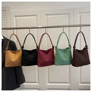 Detail showing five solid color bucket bags with knotted handles in a home closet scene