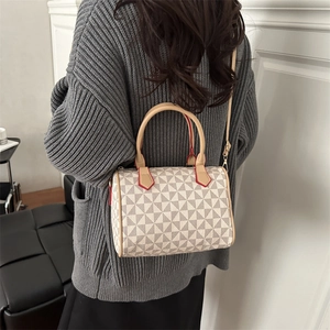 Minimalist Boston pillow bag with geometric pattern and brown leather straps on model