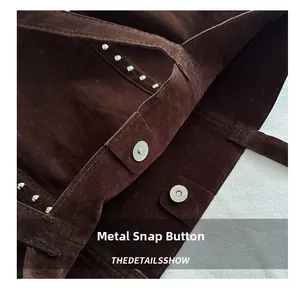 Detail of the magnetic snap closure and silver studs on the dark brown suede tote bag