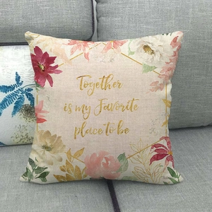 Macro shot of linen pillowcase with watercolor floral wreath and Together gold lettering