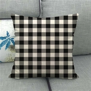 Close-up of black and white buffalo plaid linen pillow cover on a modern gray sofa
