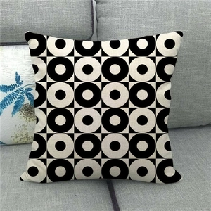 Linen cushion cover with black and white retro pop geometric circle pattern on a sofa