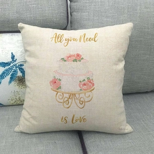 Detail of linen pillowcase with cake and rose print on a gray fabric sofa