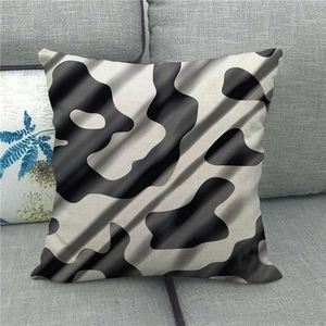 Close-up of geometric spotted linen pillowcase on a grey fabric sofa for home decor