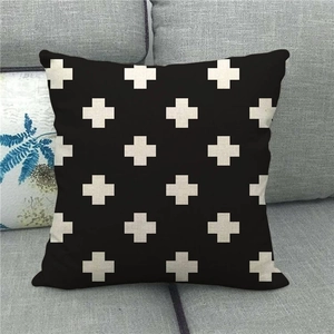 Detail of minimalist geometric cross pattern on black linen texture throw pillow cover