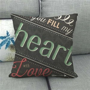 Detail of linen pillowcase with colorful 'you FILL my heart with Love' text on grey sofa