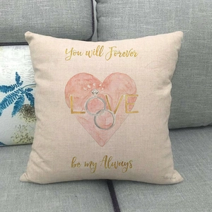 Linen pillow cover with watercolor heart, rings, and romantic text on gray sofa