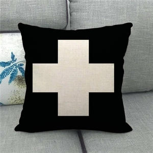 Close-up of textured linen pillowcase featuring a bold cream cross pattern on black fabric