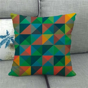 Detail shot of a linen pillowcase with colorful geometric triangle patterns on a sofa