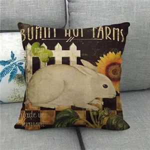 Detail of linen pillowcase with retro bunny farm and sunflower rustic design on a sofa