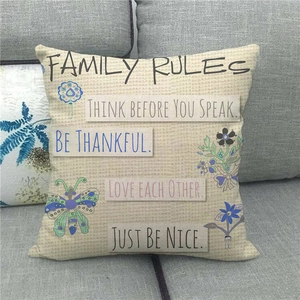 Close-up of Family Rules quote print and floral butterfly details on linen pillow cover