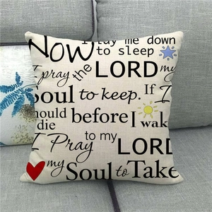 Square linen pillow cover with classic prayer text design on a gray sofa fabric