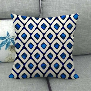 Close-up of linen cushion cover with blue and black checkered geometric pattern on gray sofa