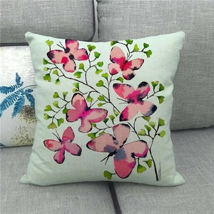 Detail of pink butterfly and leaf watercolor pattern on linen pillowcase over sofa